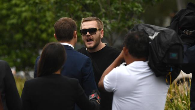 A supporter of Brae Taylor Lewis hurls abuse at reporters as he leaves the Magistrates Court in Beenleigh. Picture: AAP/Dan Peled