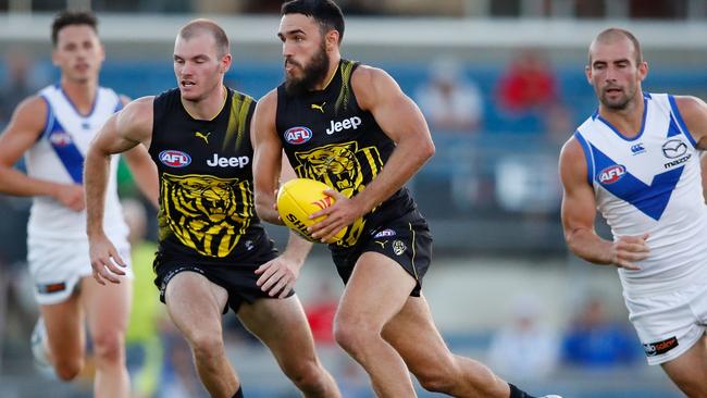 Shane Edwards powers the Tigers into attack against North Melbourne.