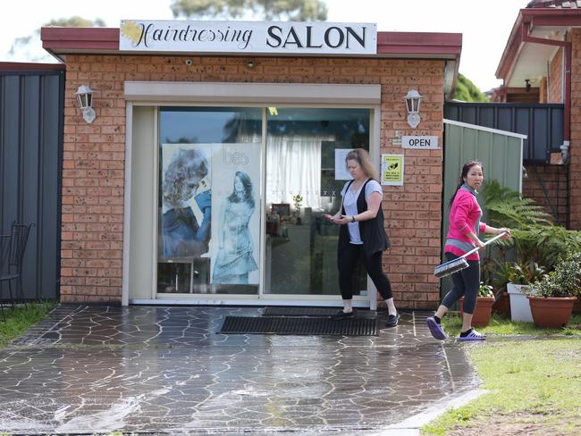 The hair dresser who sheltered the stabbing victim cleans up the blood. Picture: Stephen Cooper