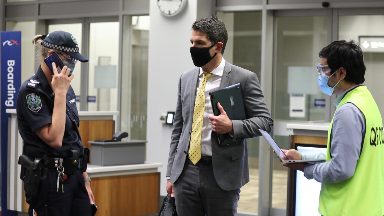 SA Senator Alex Antic speaks with staff and a police officer after landing in Adelaide. He was escorted to a medi-hotel. Picture nDean Martin