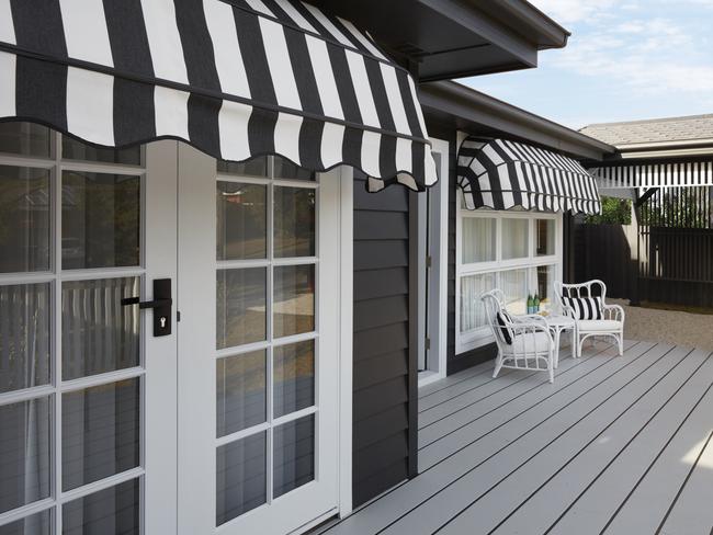 The sleek new front features a front deck, charcoal and white colours and French style awnings.