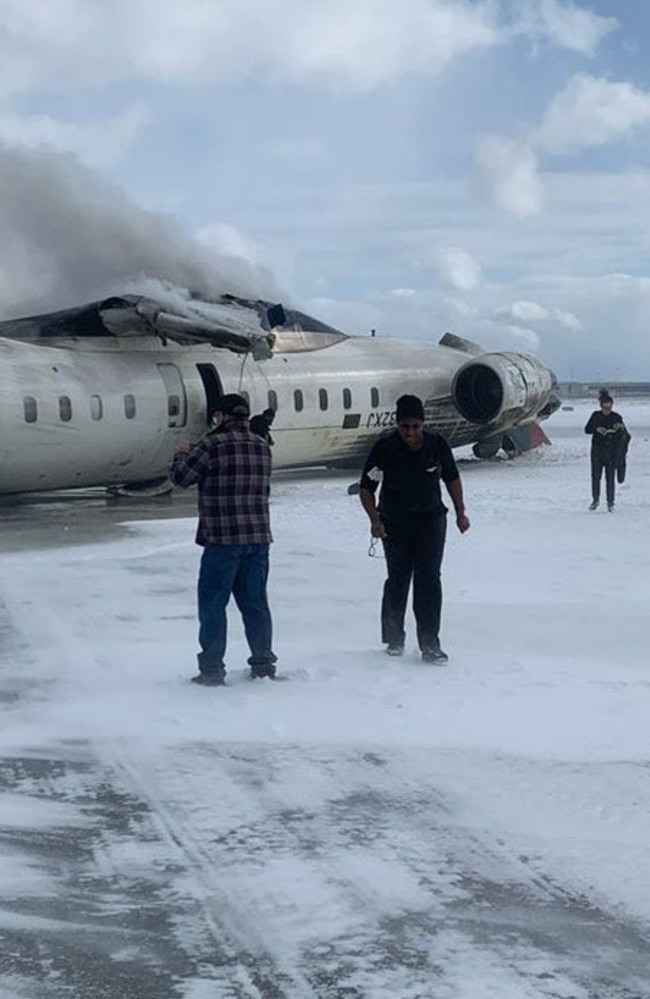 Dazed passengers walk from the Toronto plane crash. Picture: Supplied