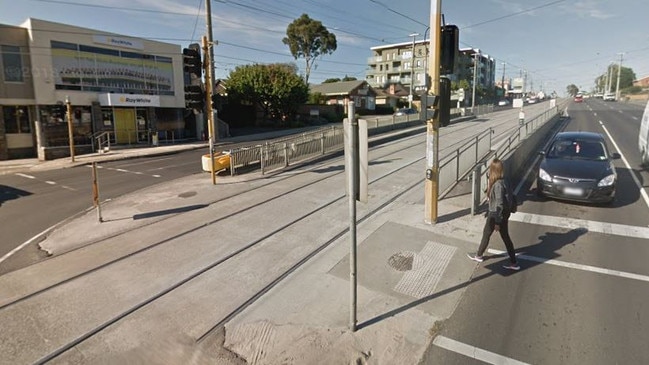 The limited space pedestrians have while waiting between traffic and passing trams at the Plenty Rd-Settlement Rd-Bent St intersection.