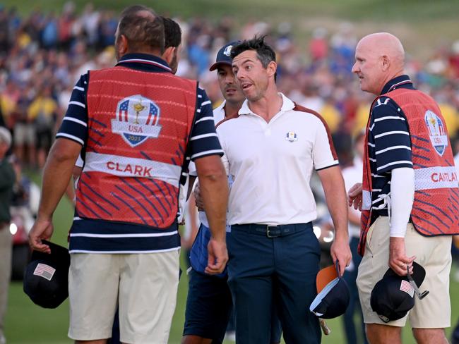 ROME, ITALY - SEPTEMBER 30: Rory McIlroy of Team Europe speaks with caddie of Wyndham Clark of Team United States (not pictured), caddie, John Ellis on the 18th green during the Saturday afternoon fourball matches of the 2023 Ryder Cup at Marco Simone Golf Club on September 30, 2023 in Rome, Italy. (Photo by Ross Kinnaird/Getty Images)