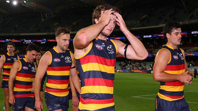 ADELAIDE, AUSTRALIA - MARCH 22: Jordon Butts of the Crows holds his head as he walks off with his team mates after the loss during the 2024 AFL Round 2 match between the Adelaide Crows and the Geelong Cats at Adelaide Oval on March 22, 2024 in Adelaide, Australia. (Photo by Sarah Reed/AFL Photos via Getty Images)