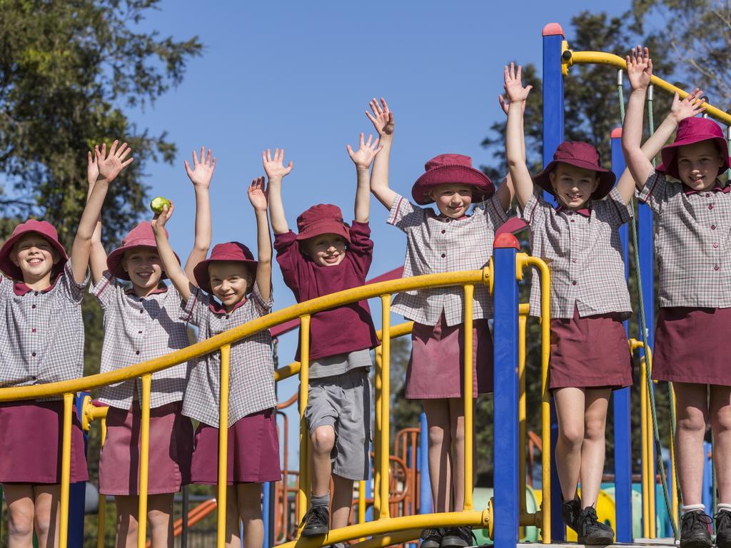 School children playing outdoors on climbing equipment in the playground