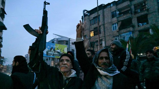 Locals in the Damascus suburb of Jaramana take to the streets on Sunday, after Syrian rebels said President Bashar al-Assad had fled the country. Picture: AFP