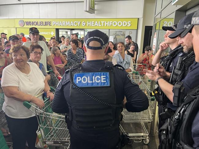 More than 200 Ingham residents await for Woolworths to open with police letting 20 customers through at a time. Picture: Cameron Bates