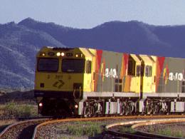 An Aurizon bulk concentrates train with Mount Stuart in the background, rail operator, mine haulage.