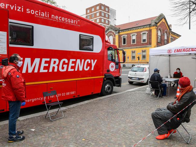 People receiving assistance at the Politruck mobile clinic of Italian humanitarian NGO Emergency, which offers free basic health care for the homeless, the excluded and people with no financial resources in Milan. Picture: AFP