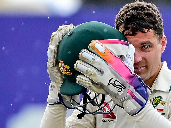 Alex Carey removes his helmet as rain stops play at Galle. Picture: AFP