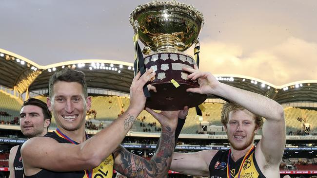 Jesse White and Joshua Scott celebrate Glenelg’s premiership win with the Thomas Seymour Hill trophy Picture SARAH REED