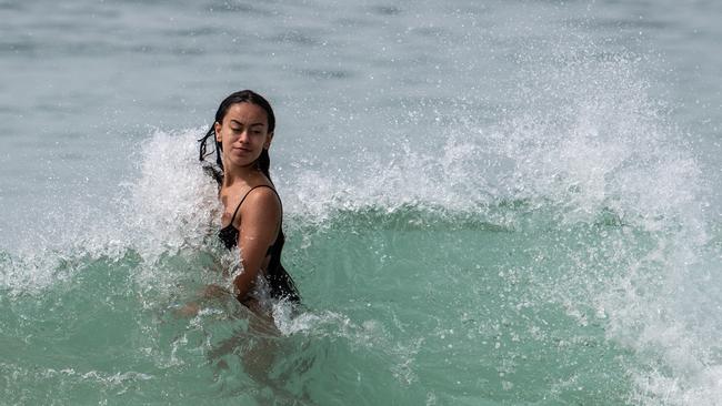 A beachgoer tackles the heat and waves at Bondi Beach on Sunday morning. Picture: James Gourley/ NCA Newswire