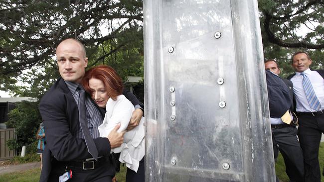 Australian Prime Minister Julia Gillard is bundled out of a restaurant by security service agents after it was surrounded by furious Aboriginal rights protesters in Canberra on January 26, 2012. Mackay was one of the instigators. Picture: AAP / Lukas Coch