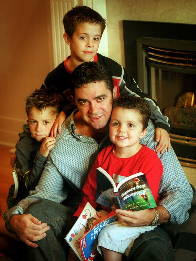 Garry Lyon reads to his children Josh, Ben and Thomas.