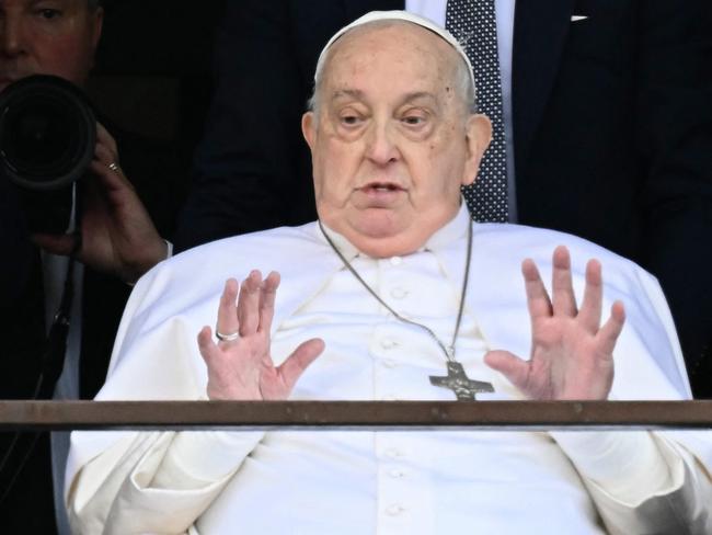 Pope Francis waves from a window of the Gemelli hospital before being discharged following a five weeks hospitalization for pneumonia, in Rome on March 23, 2025. Pope Francis is to leave hospital todayand return to his residence in the Vatican, where he is to spend "at least two months" recovering, one of his doctors announced during a press conference on March 22, 2025. (Photo by Filippo MONTEFORTE / AFP)