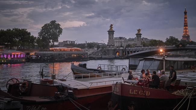 Parisians enjoy an evening meal on a housboat at dusk over the weekend. Picture: Getty Images