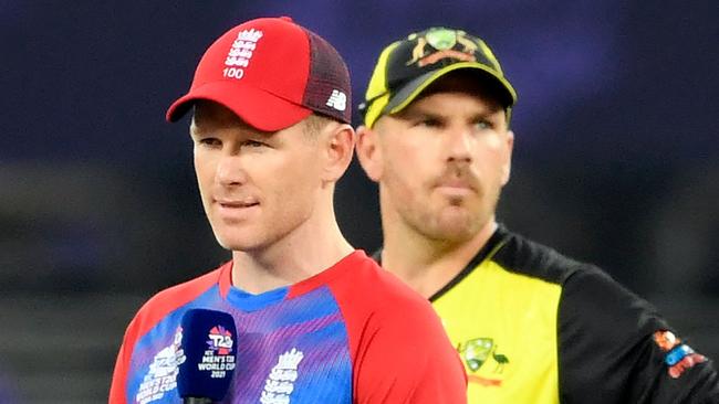 England's captain Eoin Morgan (L) speaks as his Australian counterpart Aaron Finch watches before the start of the ICC menâ&#128;&#153;s Twenty20 World Cup cricket match between Australia and England at the Dubai International Cricket Stadium in Dubai on October 30, 2021. (Photo by Aamir QURESHI / AFP)