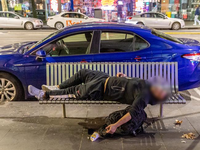 A man sleeps on a bench in Elizabeth Street. Picture: Jake Nowakowski