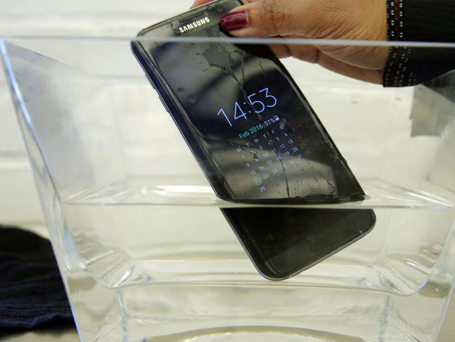 FILE - In this Feb. 22, 2016 file photo, a waterproof Samsung Galaxy S7 Edge mobile phone is submersed in water during a preview of Samsung's flagship store, Samsung 837, in New York's Meatpacking District. SquareTrade, a company that offers extended-protection plans for gadgets, said the Galaxy S7 and S7 Edge still functioned after being submerged in water for 30 minutes. Audio was “permanently muffled and distorted” after the dunking, but the Samsung phones still outlasted Apple’s iPhones in SquareTrade’s water tests. The study, released Monday, March 14, also found that Samsung’s new phones are more prone to breaking than the iPhone 6S, which survived 30 seconds in a tumbling test chamber, similar to a dryer without heat. (AP Photo/Richard Drew, File)