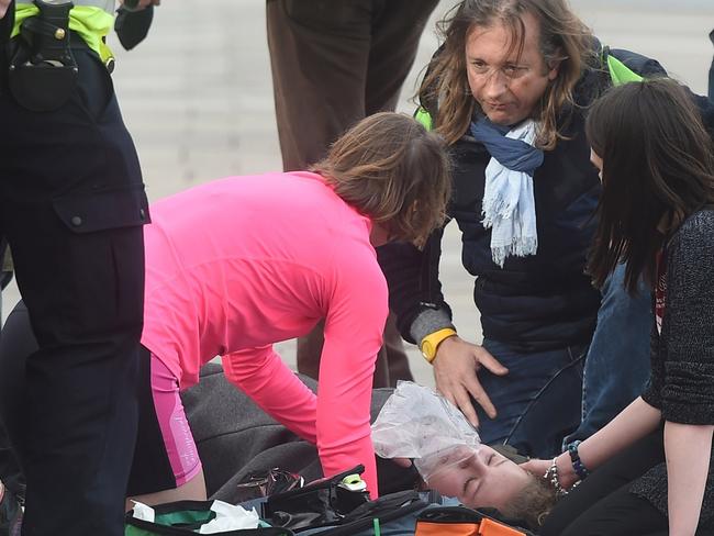 Victims of the attack are assisted by pedestrians. Picture: FameFlynet UK