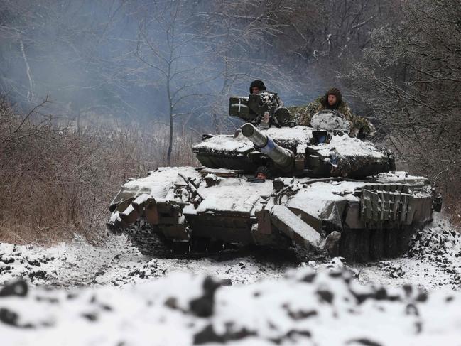 TOPSHOT - Ukrainian soldiers drive a tank in a position near to the town of Bakhmut, Donetsk region, on December 13, 2023, amid the Russian invasion of Ukraine. (Photo by Anatolii STEPANOV / AFP)