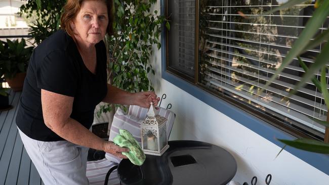 The Pines resident Glenda Walker cleans two weeks’ worth of dust from her outdoor table. Hers is one of 180+ signatures on a petition calling for the township’s roads to be sealed. Picture: Naomi Jellicoe