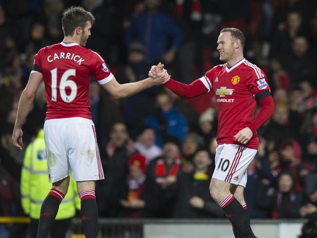 Manchester United's Wayne Rooney, right, shakes hands with teammate Michael Carrick after scoring during the English Premier League soccer match between Manchester United and Stoke at Old Trafford Stadium, Manchester, England, Tuesday, Feb. 2, 2016. (AP Photo/Jon Super)