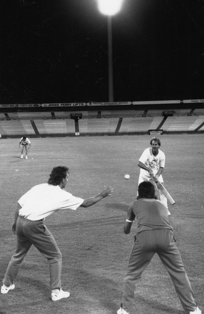 SA cricket captain David Hookes hits catches to fast bowlers Colin Miller and Shane George practice under lights at Football Park in 1990.