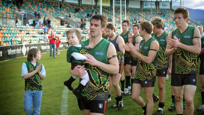 The last VFL game for the Tasmanian Devils team, skipper Brett Geappen leads the team off carrying one year old daughter, Penelope.