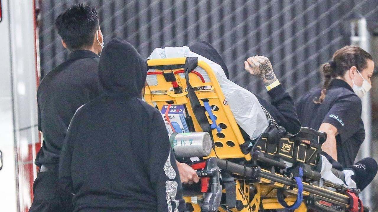 Travis Barker was seen being transported on a stretcher, accompanied by wife Kourtney who was dressed in a black hooded tracksuit. Picture: Backgrid