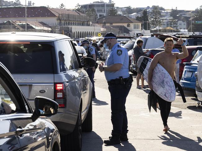 SYDNEY, AUSTRALIA - AUGUST 15: Police conduct public health order compliance checks as people arrive at Bondi Beach on August 15, 2021 in Sydney, Australia. The whole state of New South Wales is now under stay-at-home orders as NSW health authorities work to contain an outbreak of the highly contagious delta COVID-19 strain. From Monday 16 August, the 10km travel rule in Greater Sydney will be reduced to 5km, limiting residents to a 5km radius from their homes. New spot fines for breaching COVID-19 rules will also come into effect including $5000AUD fines for quarantine breaches and $3000AUD for travel breaches.  (Photo by Brook Mitchell/Getty Images)