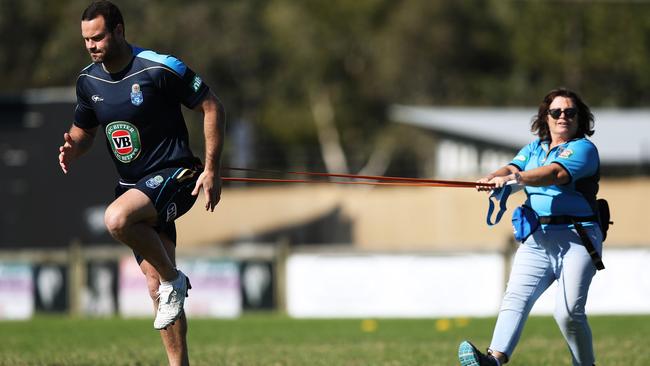 Working on Boyd Cordner’s injured calf. (Brett Costello)