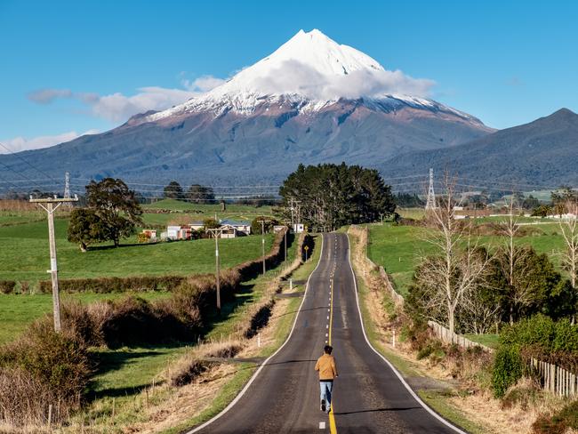 ESCAPE:  Man runs on a straight road toward snow mountain. Running outdoors concept. Achieve goal, motivation and determination concept. Picture: Istock