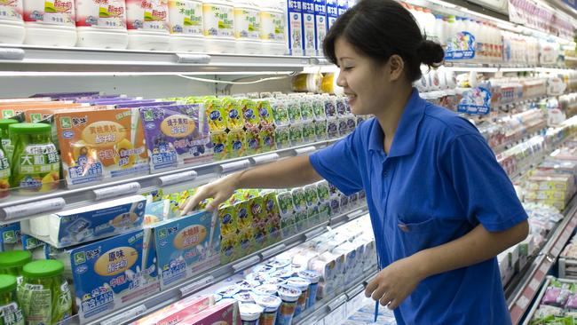 A clerk stocks China Mengniu Dairy Co. products at a supermarket in Beijing, China. Picture: Bloomberg