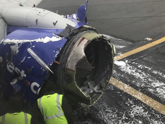 The engine on a Southwest Airlines plane is inspected as it sits on the runway at the Philadelphia International Airport after it made an emergency landing in Philadelphia. Picture: AP