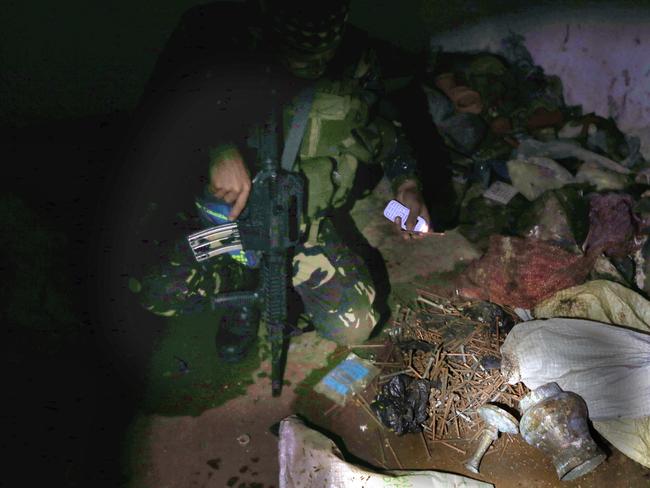 Soldiers from the 1st Field Artillery Battalion looking at what ISIS soldiers left behind in Marawi. Picture: Gary Ramage