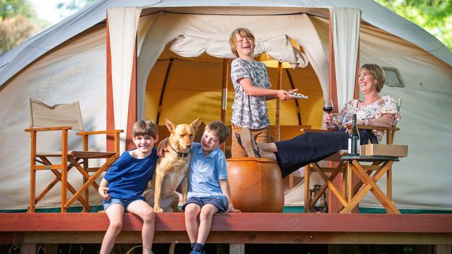 Daylesford Holiday Park owner Jodie Jagoe at the park's glamping accommodation with Joey, 9, Tom, 8, and Jesse, 6, and Gypsy the yellow kelpie. Picture: Mark Stewart