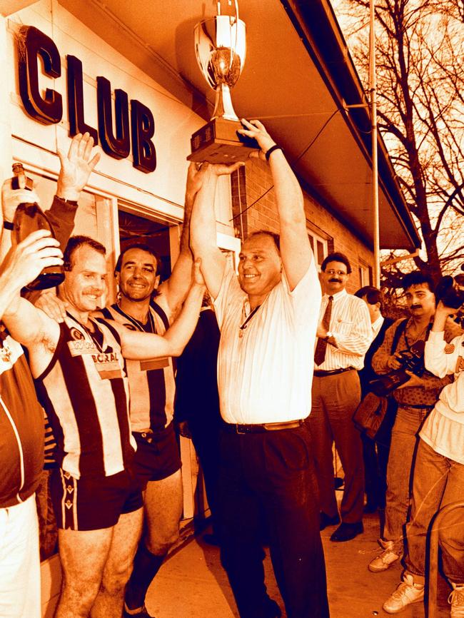 Wodonga coach Jeff Gieschen lifts the premiership cup after the 1990 Bloodbath grand final.