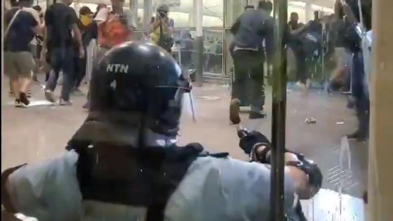 The moment a Hong Kong police officer draws his gun at the city's airport as protests escalate. Picture: Twitter / Mike Bird Wall Street Journal