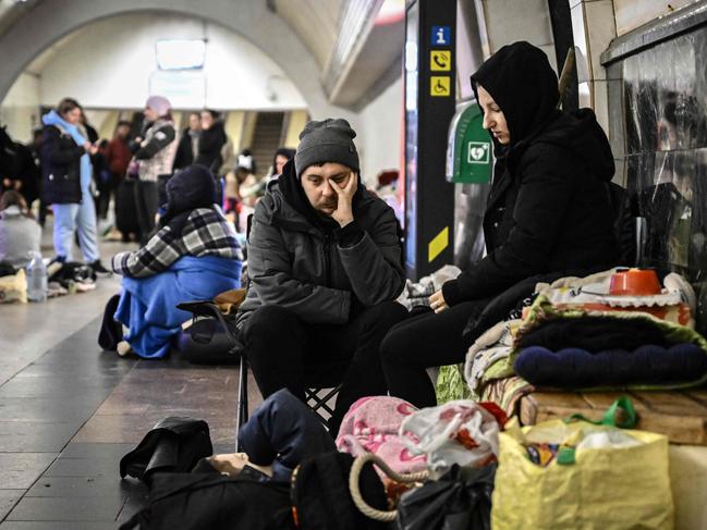 A couple sits in an underground metro station used as bomb shelter in Kyiv. Picture: AFP