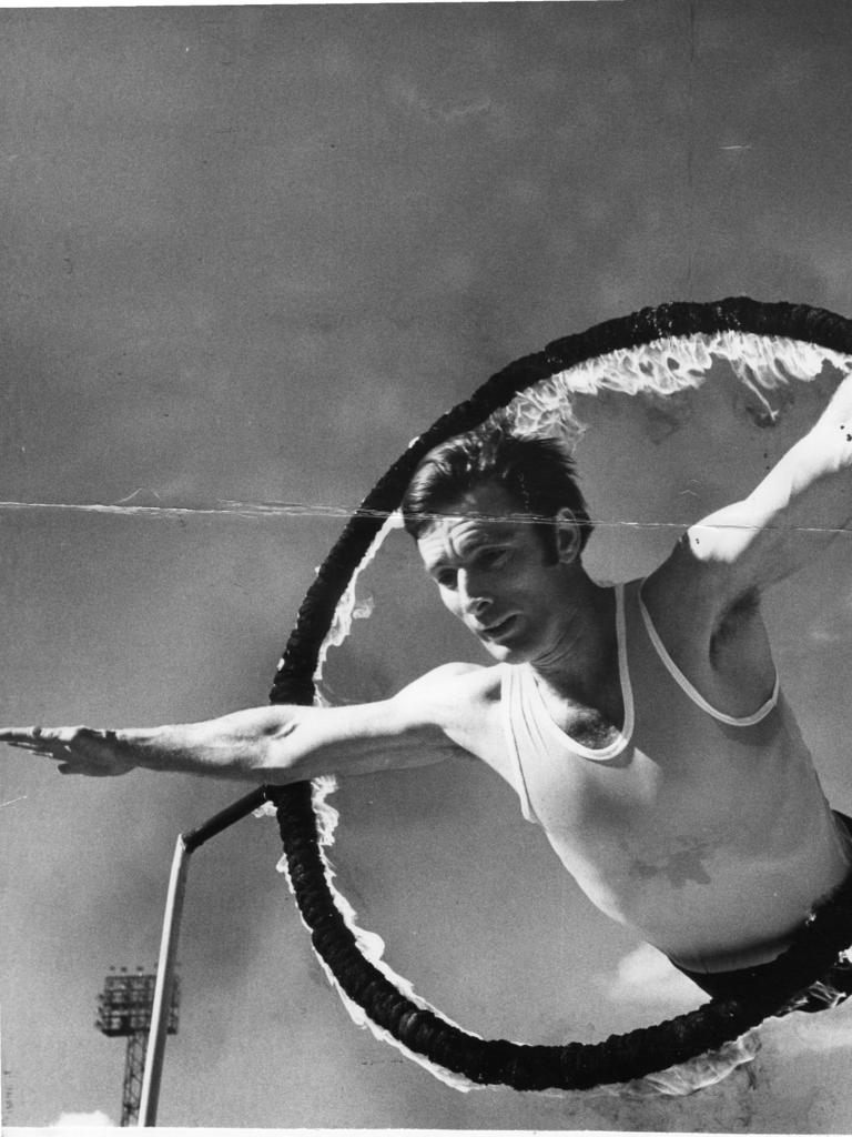 Royal Adelaide Show, 1976. CPO Mitchell dives through a flaming hoop during the Navy team's practice session at the Wayville Showground.