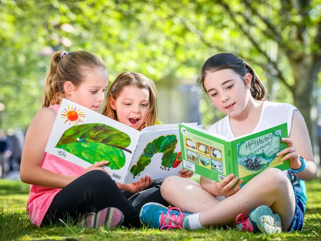 Casey Boyd, 9, Madison Boyd, 4 and Tia Dempsey, 9 read The Very Hungry Caterpillar and Hair Maclary. Picture: Jake Nowakowski