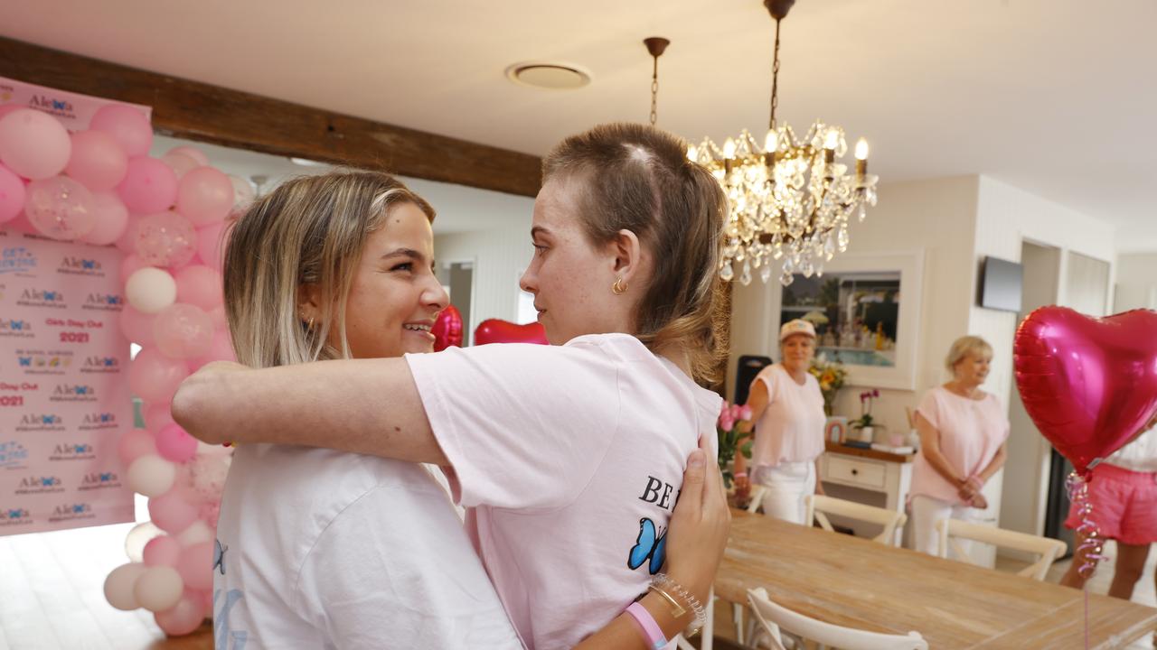 Alexa hugging best friend Emma Benjamin on her return to her family home in Noosaville after four months in hospital. Picture Lachie Millard