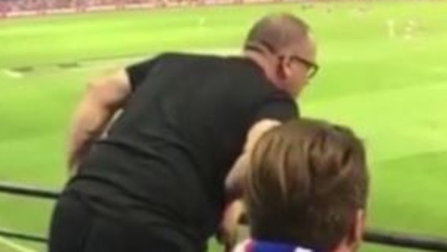 An AFL fan is filmed allegedly hurling racial abuse at a trainer