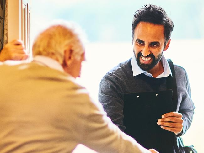 Young male community healthcare worker being welcomed by a senior man at his home; Aged care home care visit, senior generic