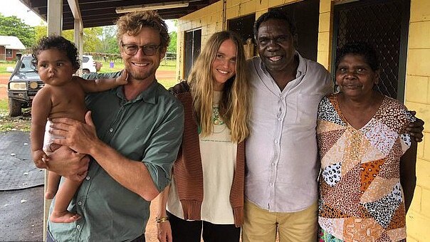 Simon Baker was pictured with his new girlfriend Laura May Gibbs (centre) on Facebook as the couple posed alongside Yirrkala community members in the Northern Territory. Picture: Supplied