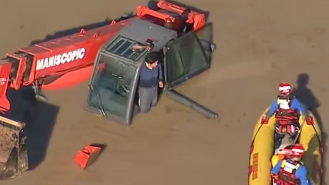 A man clinging to an excavator has been rescued by SES volunteers, at Erskine Park. After Sydney received extremely heavy rain. Picture: 9NEWS