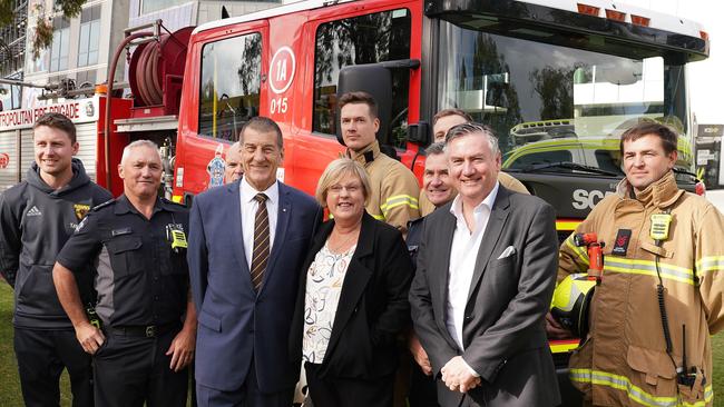 Jeff Kennett, Police and Emergency Services Minister Lisa Neville and Eddie McGuire pose with Emergency Service workers.