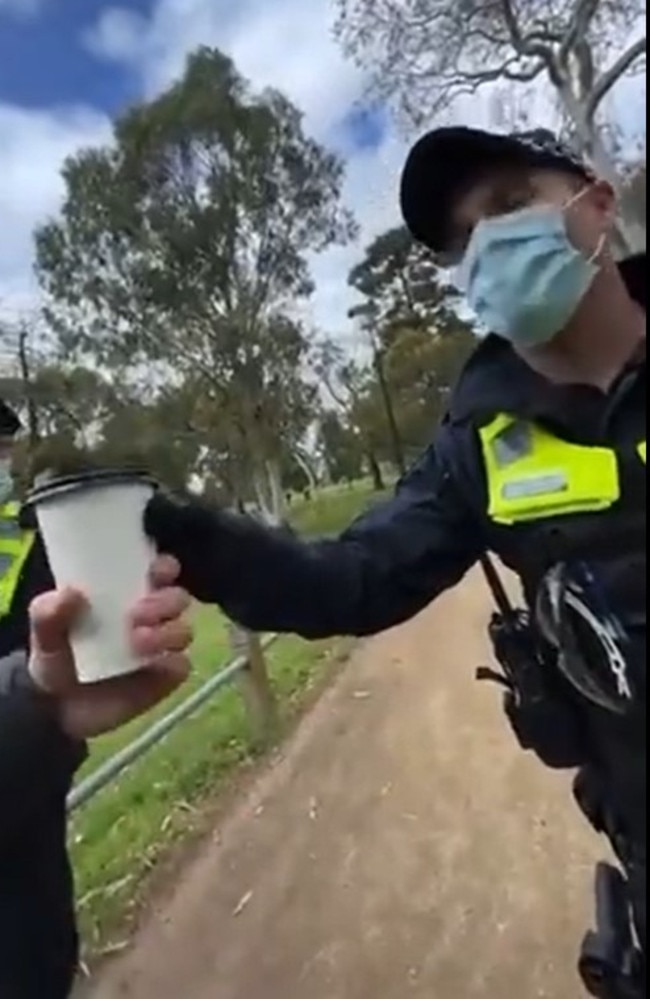 The Victorian officer took the coffee cup to check if it had any drink still inside which allowed the user not to wear a mask. Picture: Twitter/@OzraeliAvi